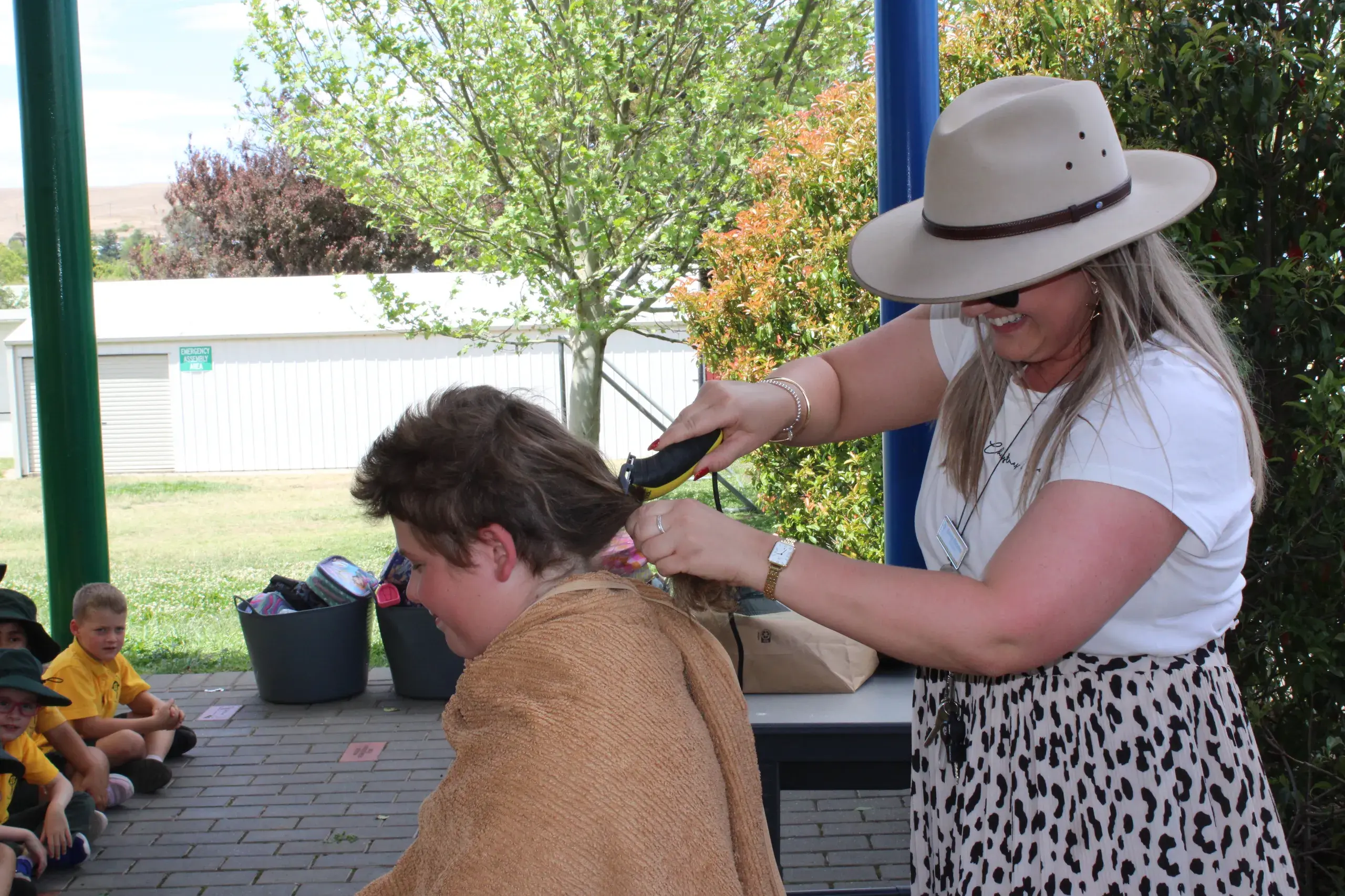 <p>GOING, GOING, GONE: Saint Patrick\\'s School, Cooma, teacher, Emma Reneker, takes great delight in cutting off the mullet part of Peter Cox\\u2019s hair.</p>\\n